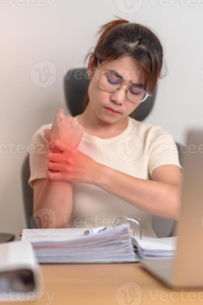 Woman having wrist pain when using laptop computer and mouse during working long time on workplace. De Quervain s tenosynovitis, rheumatism ergonomic, Carpal Tunnel Syndrome or Office syndrome concept photo
