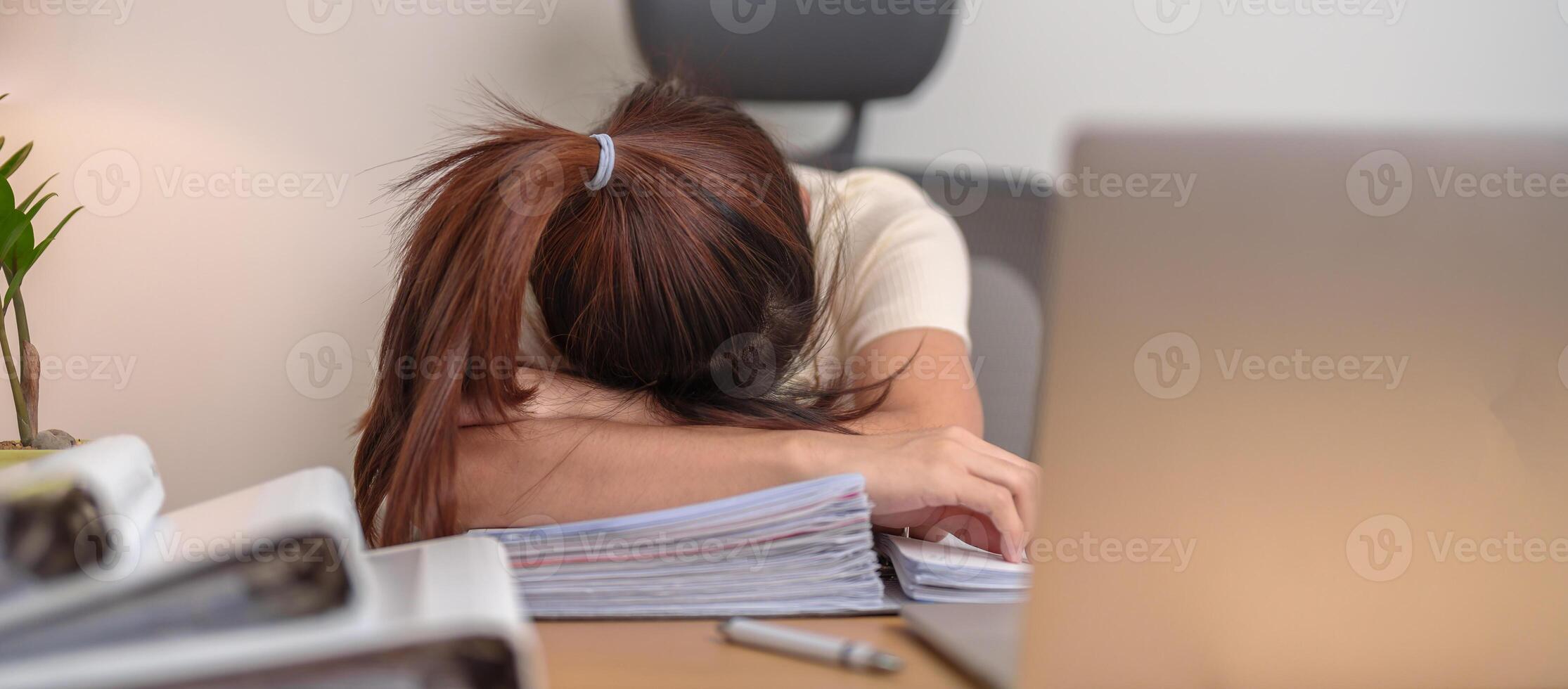 Stressed Asian woman having Tired and Sleepy while working, female businesswoman using laptop with headache at office, Exhausted woman with computer at home late night. Overload and Overworked photo