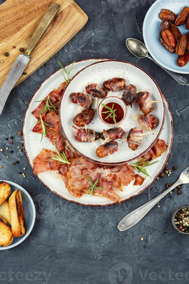 Italian bacon wrapped dates appetizer. photo