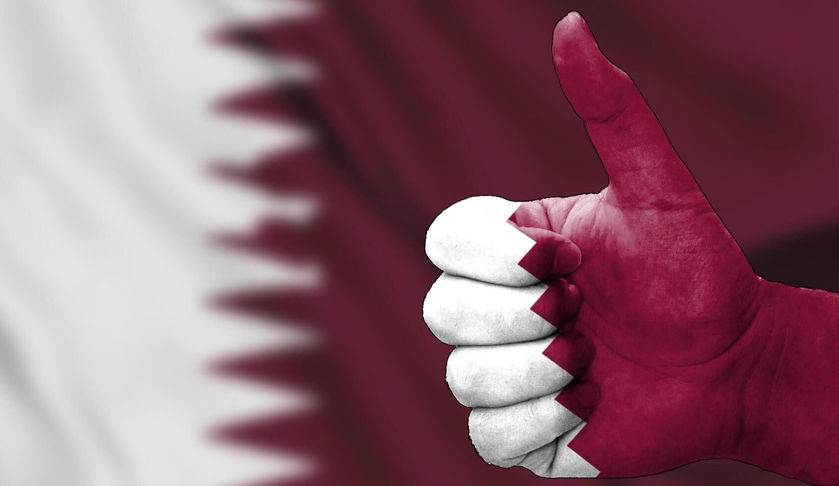thumbs up in approval with the Qatari flag painted photo