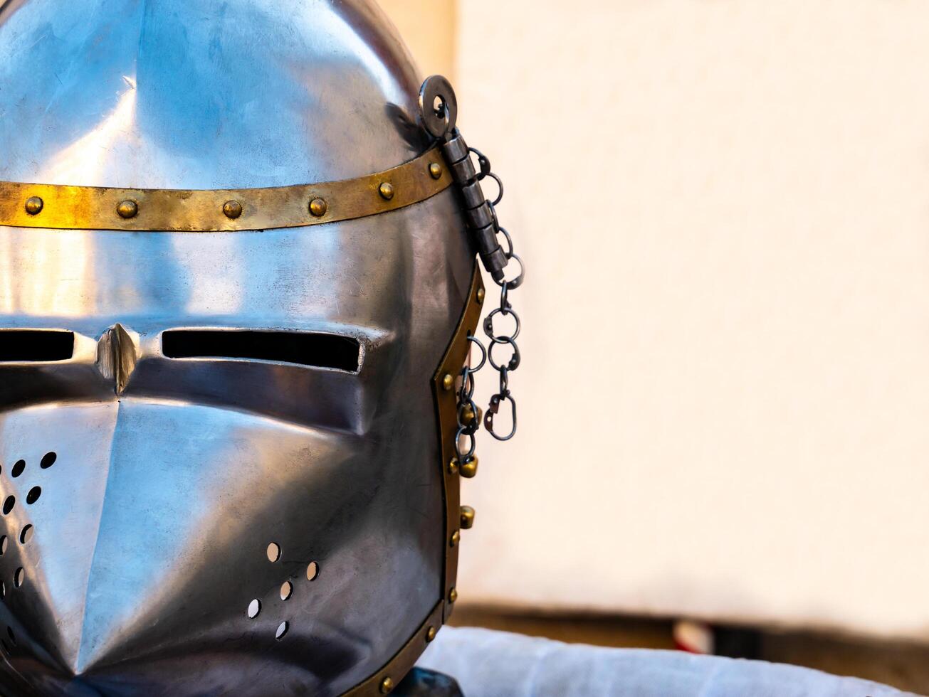 close up shot of a medieval metal helmet from one side and a blank white banner in the background. photo
