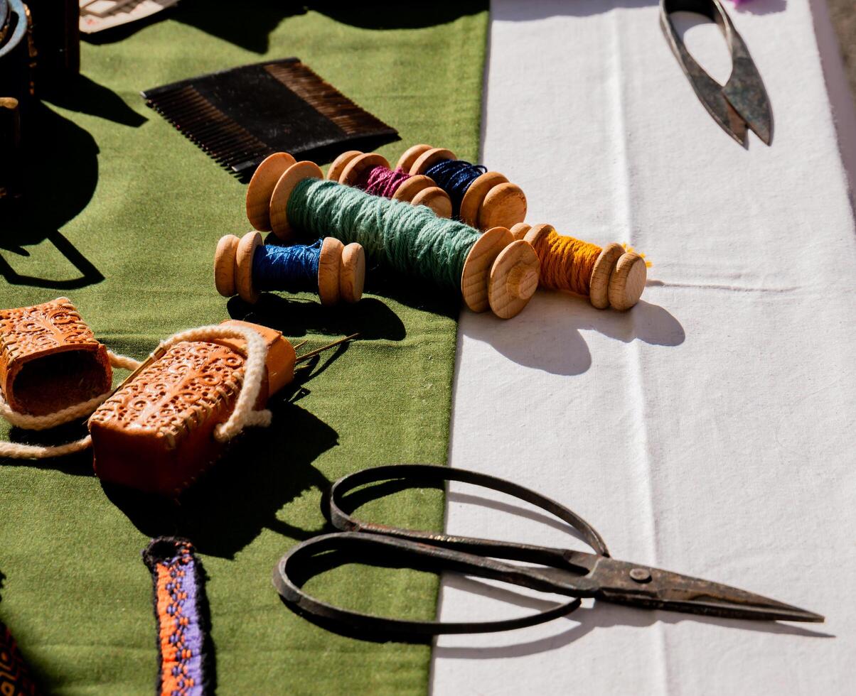 shot of ancient medieval sewing textile tools on a work table with bobbins and needles photo