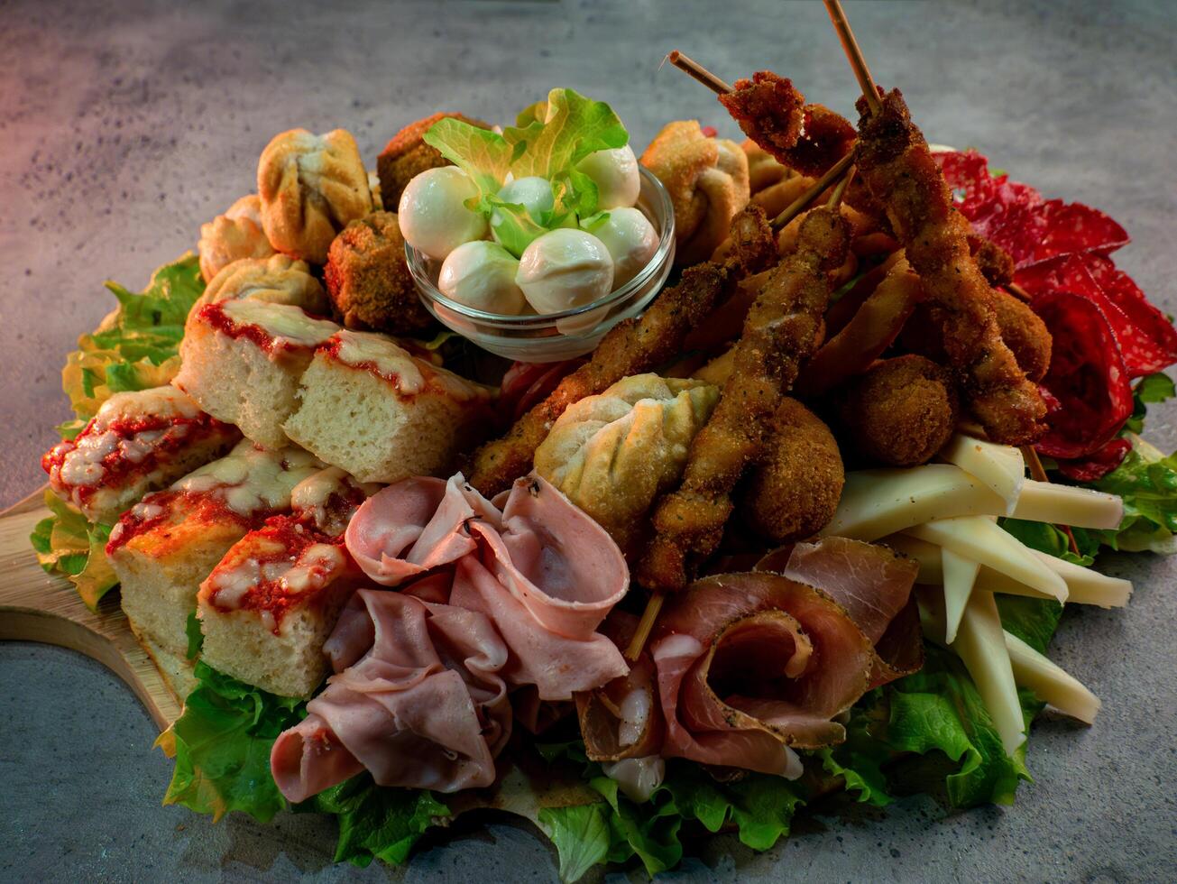 close up shot of a plate of salty snacks on a tray for an Italian aperitif or appetizers for a party photo