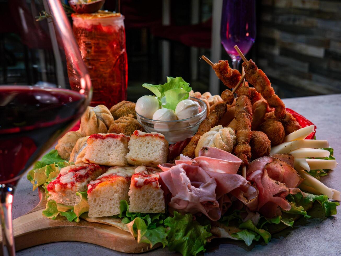 close up shot of a plate of salty snacks on a tray for an Italian aperitif or appetizers for a party photo
