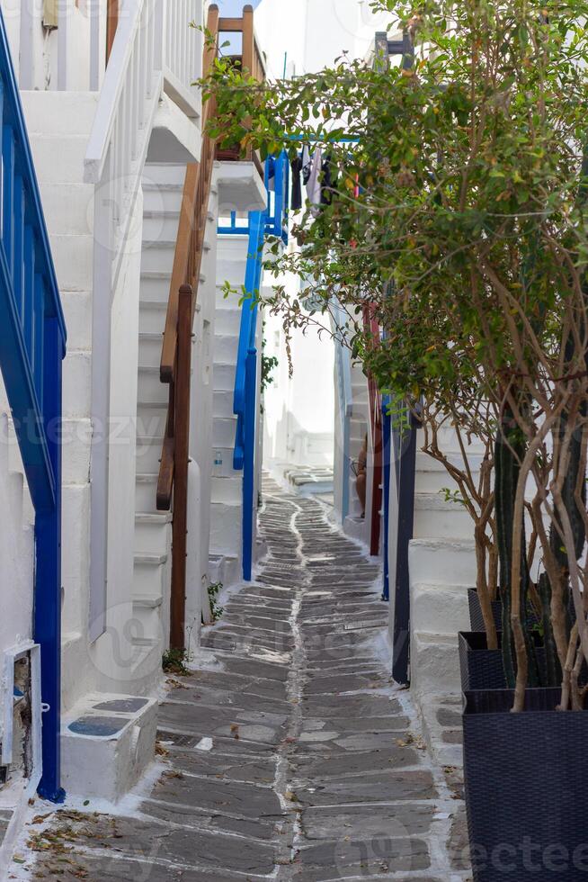 Whitewashed alley with stairs and colorful doors and windows in Mykonos, Greece. Traditional Cycladic architecture. photo