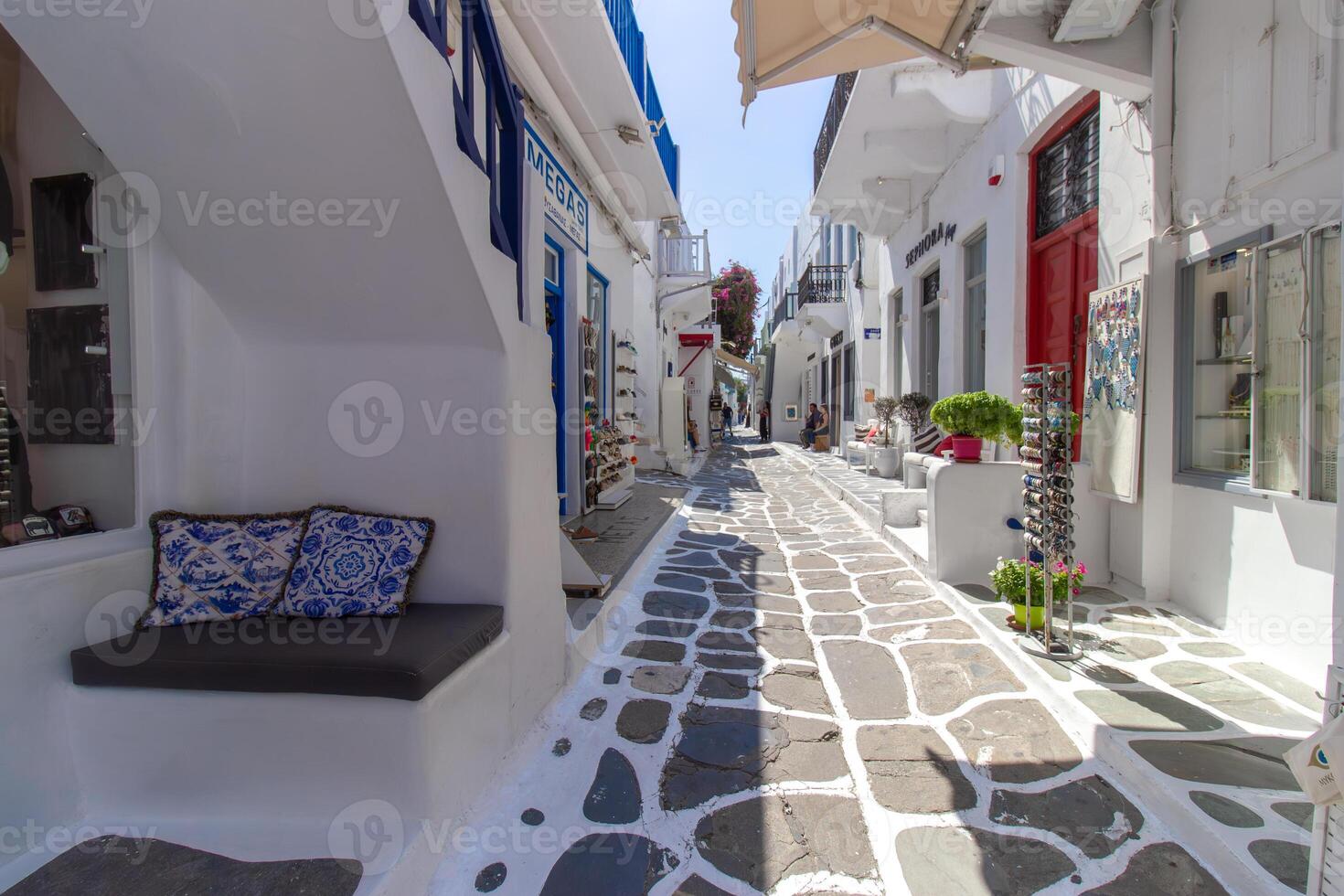Whitewashed alley with stairs and colorful doors and windows in Mykonos, Greece. Traditional Cycladic architecture. photo