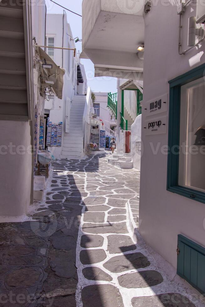 Whitewashed alley with stairs and colorful doors and windows in Mykonos, Greece. Traditional Cycladic architecture. photo