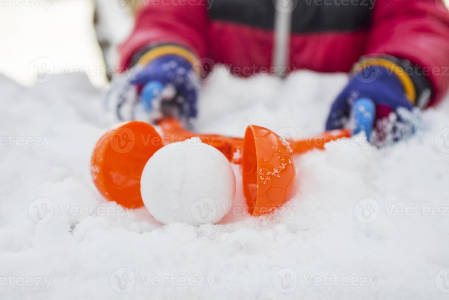 Device for sculpting snowballs in childrens hands on background of snow photo