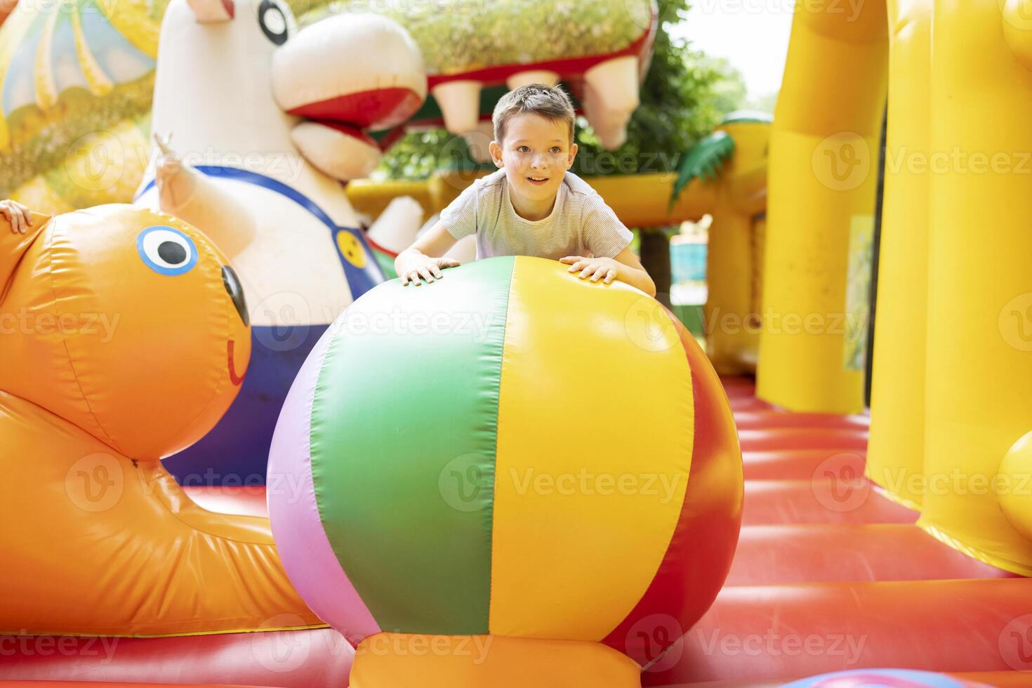 Happy boy having a lots of fun on a colorful inflate castle photo