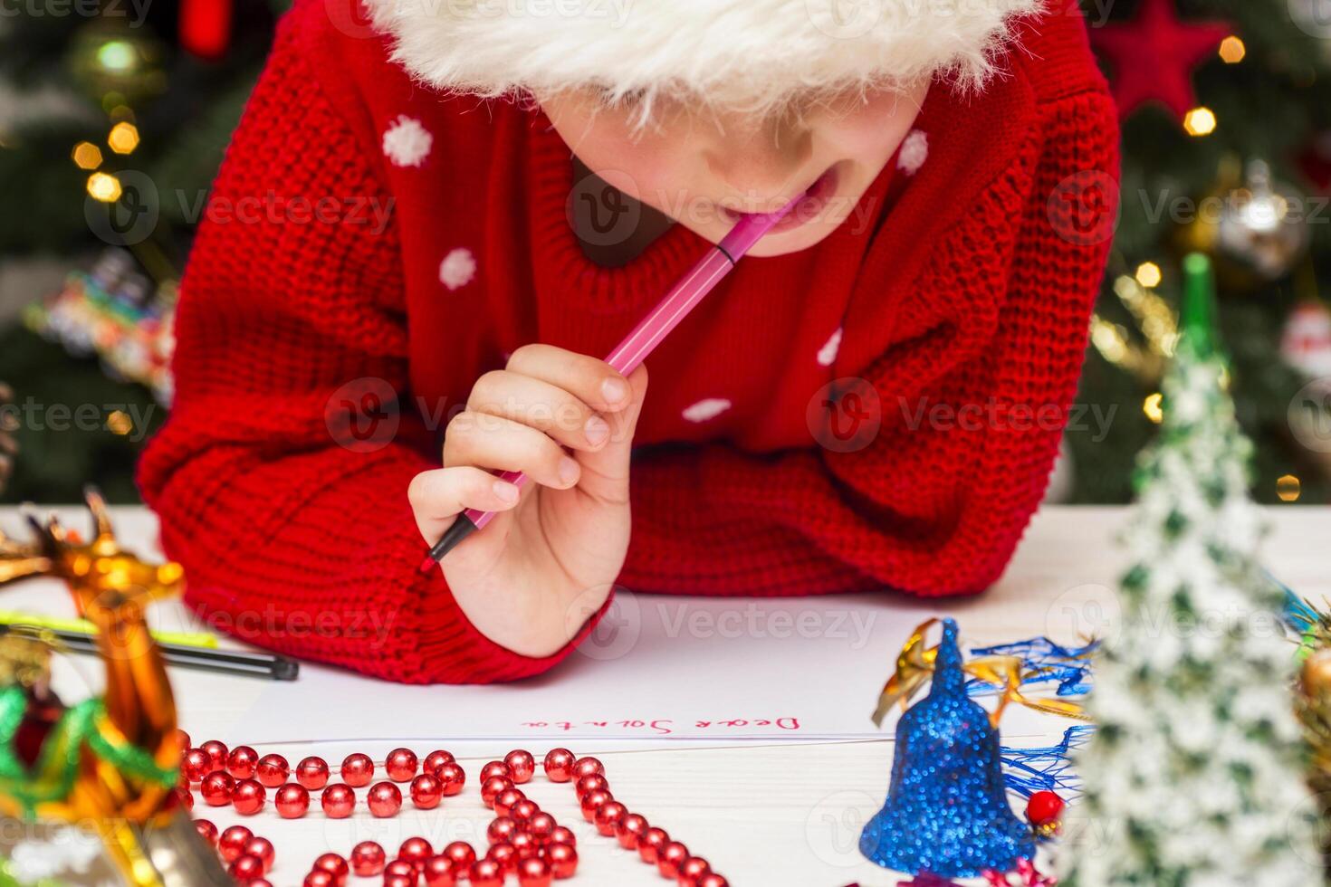 Little child is writing letter to Santa Claus at table photo