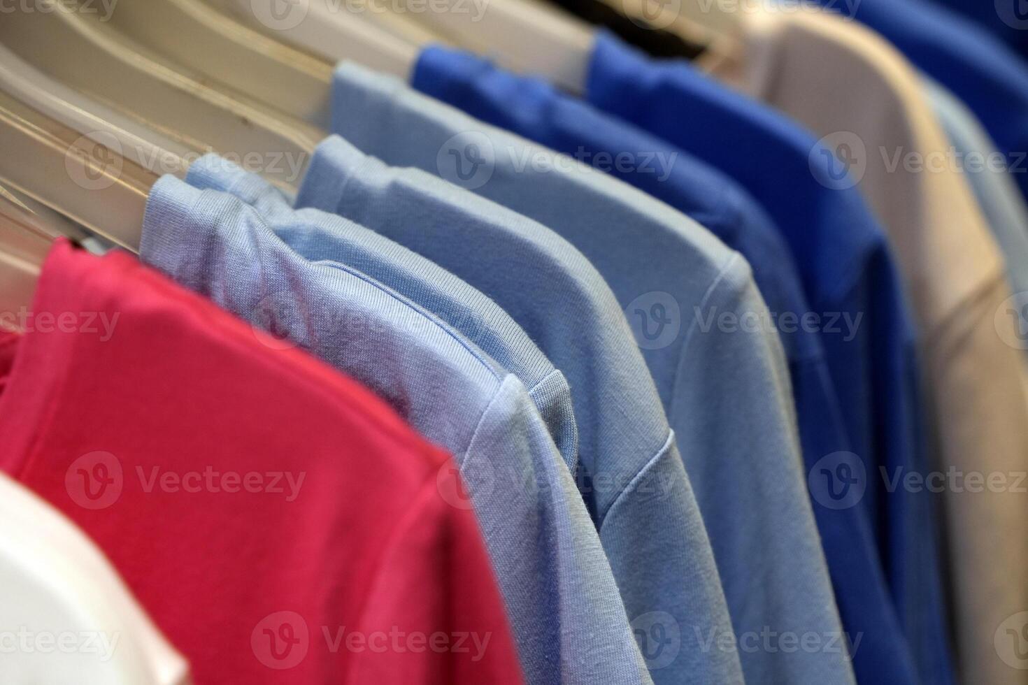 many different colors cotton shirts hanging photo