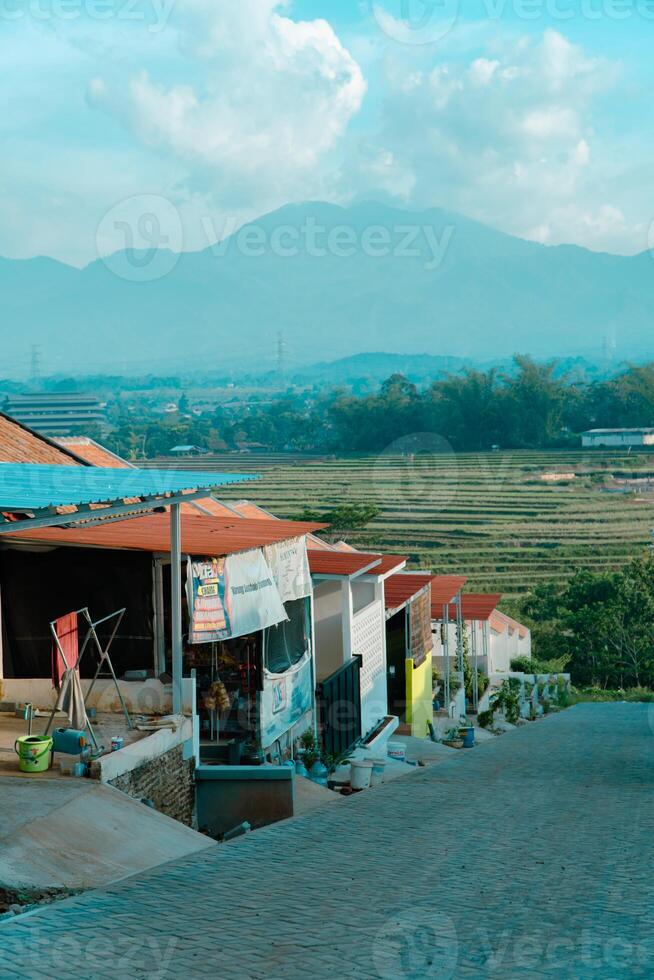 Residential area with beautiful views with a backdrop of green rice fields and mountains that look magnificent from a distance. Public housing complex on hills with sloping land with mountain views photo