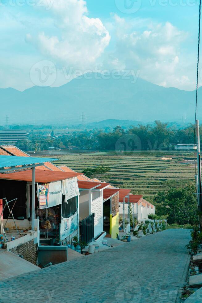 Residential area with beautiful views with a backdrop of green rice fields and mountains that look magnificent from a distance. Public housing complex on hills with sloping land with mountain views photo