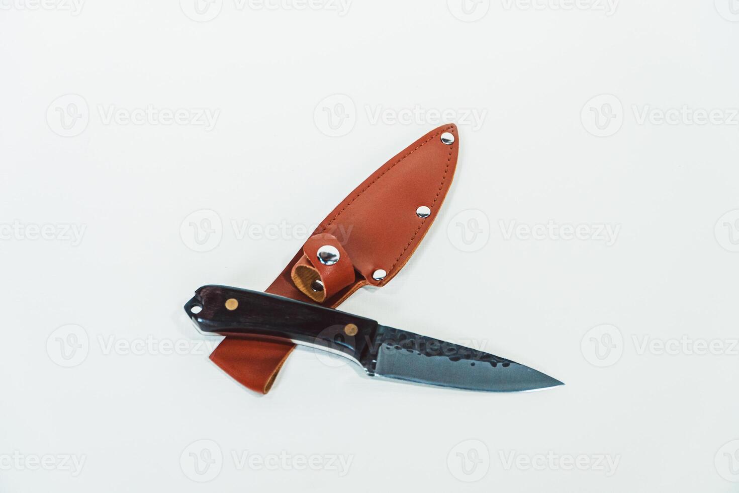 Close-up of a wooden handled adventure knife with a leather sheath. Pocket knife with a sharp stainless steel blade with a wooden handle, perfect for outdoor adventures and bushcraft activities photo