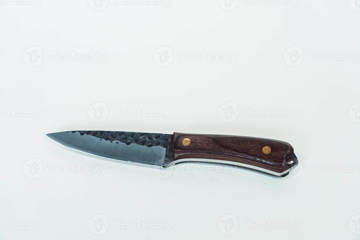 Close up of an adventure and bushcraft knife using a wooden handle. Knife with a sharp stainless steel blade with a wooden handle, perfect for outdoor adventures and bushcraft activities photo