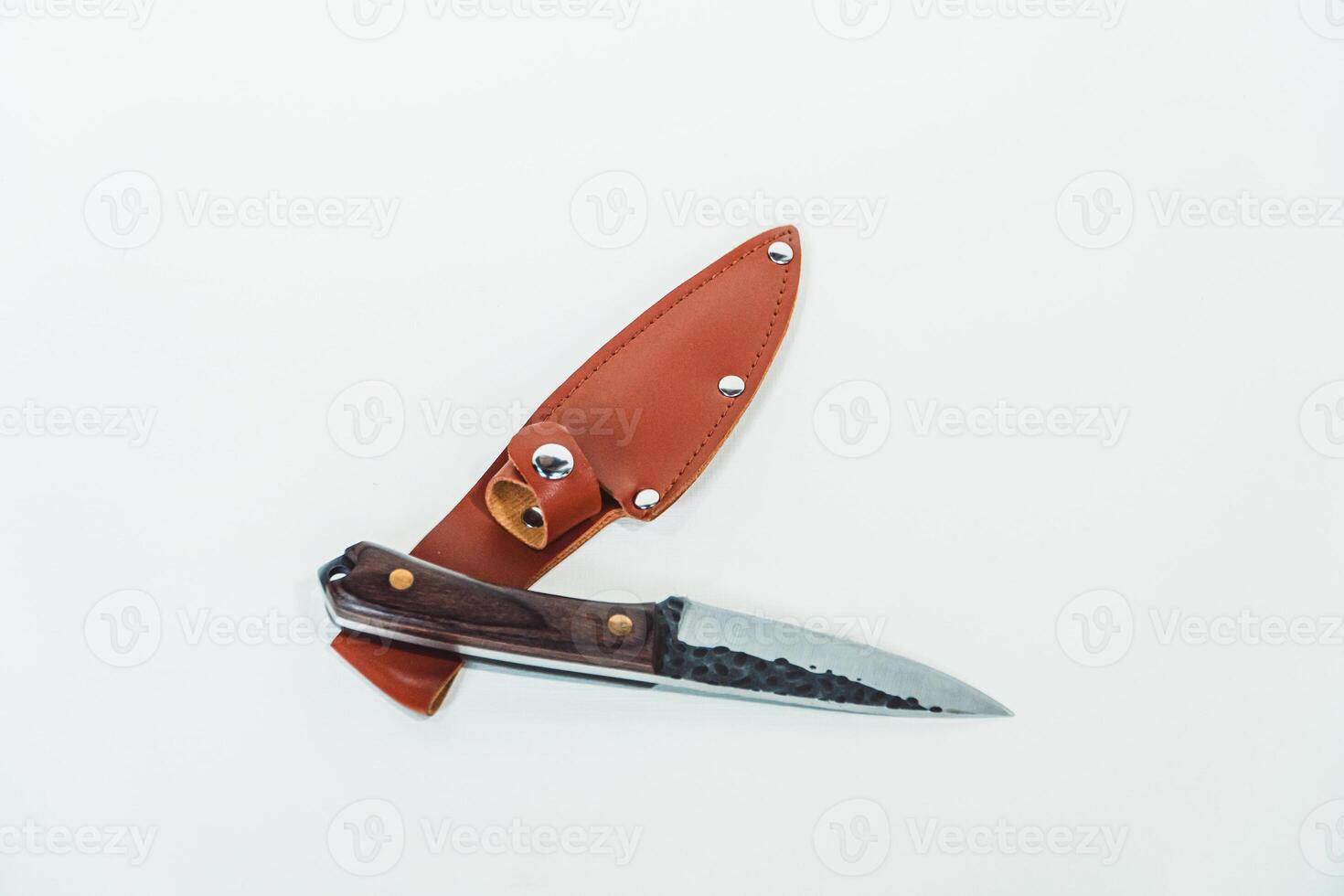 Close-up of a wooden handled adventure knife with a leather sheath. Pocket knife with a sharp stainless steel blade with a wooden handle, perfect for outdoor adventures and bushcraft activities photo