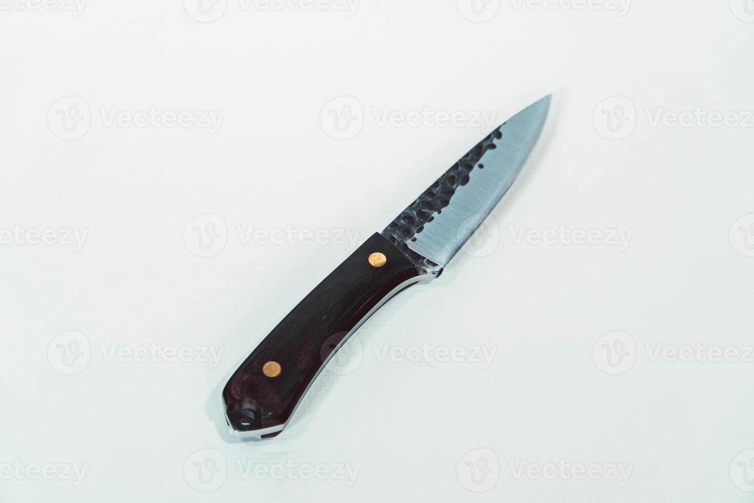 Close up of an adventure and bushcraft knife using a wooden handle. Knife with a sharp stainless steel blade with a wooden handle, perfect for outdoor adventures and bushcraft activities photo