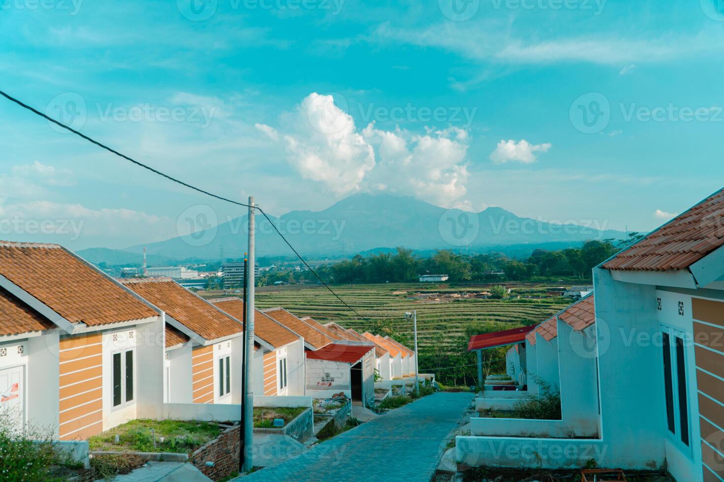 Residential area with beautiful views with a backdrop of green rice fields and mountains that look magnificent from a distance. Public housing complex on hills with sloping land with mountain views photo