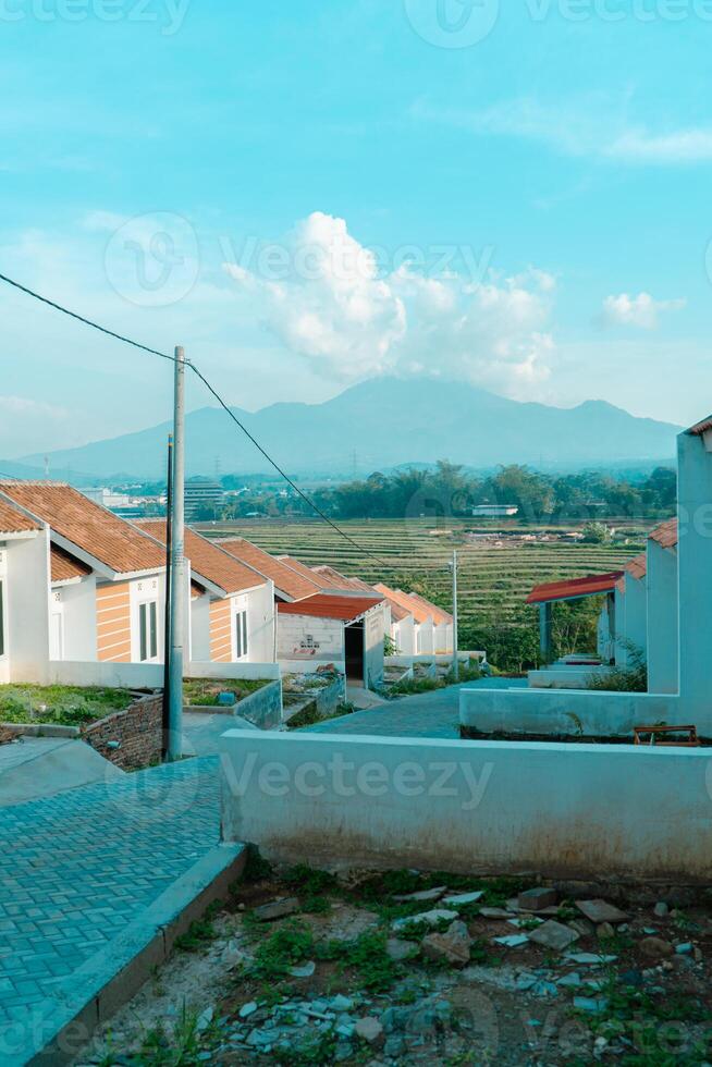 Residential area with beautiful views with a backdrop of green rice fields and mountains that look magnificent from a distance. Public housing complex on hills with sloping land with mountain views photo