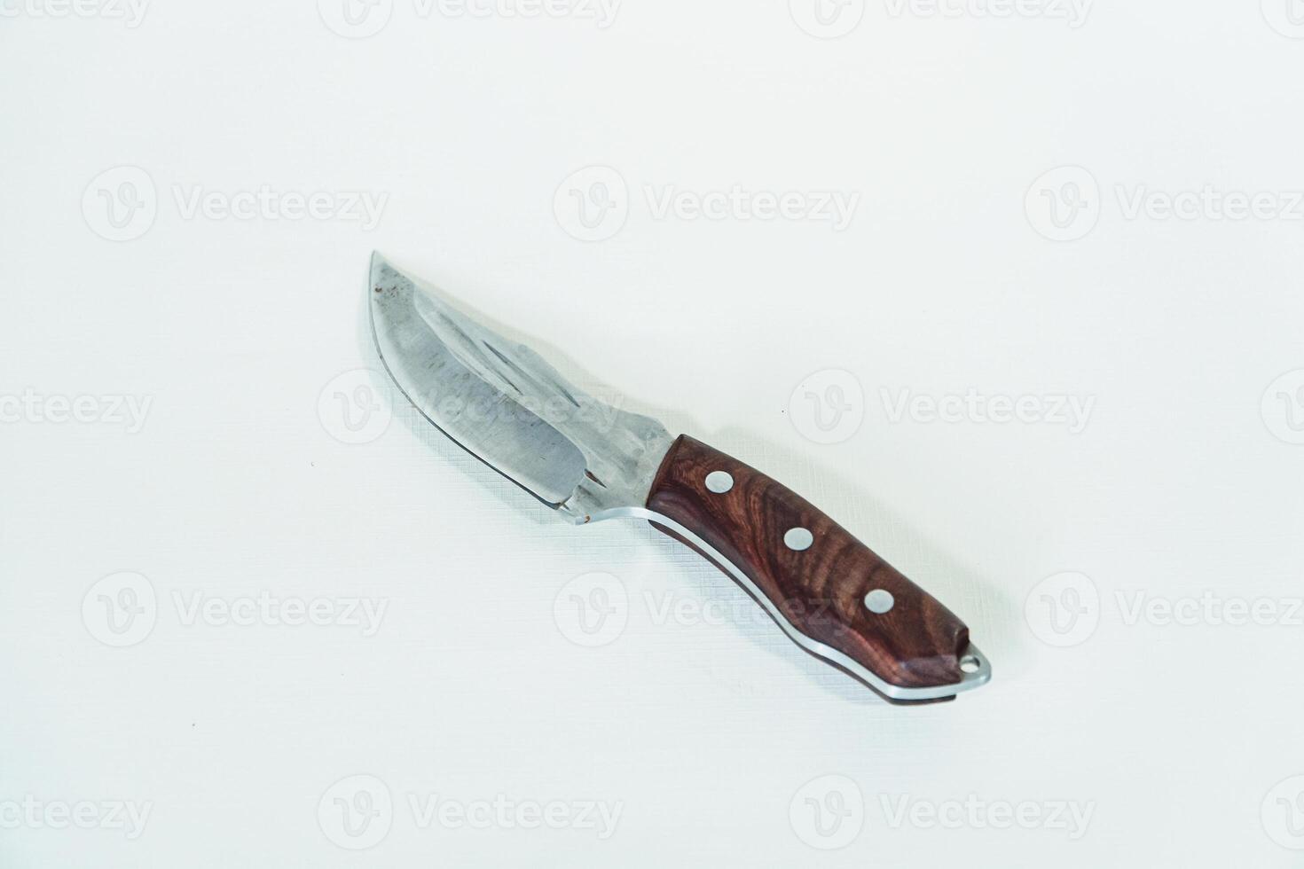 Close up of an adventure and bushcraft knife using a wooden handle. Knife with a sharp stainless steel blade with a wooden handle, perfect for outdoor adventures and bushcraft activities photo