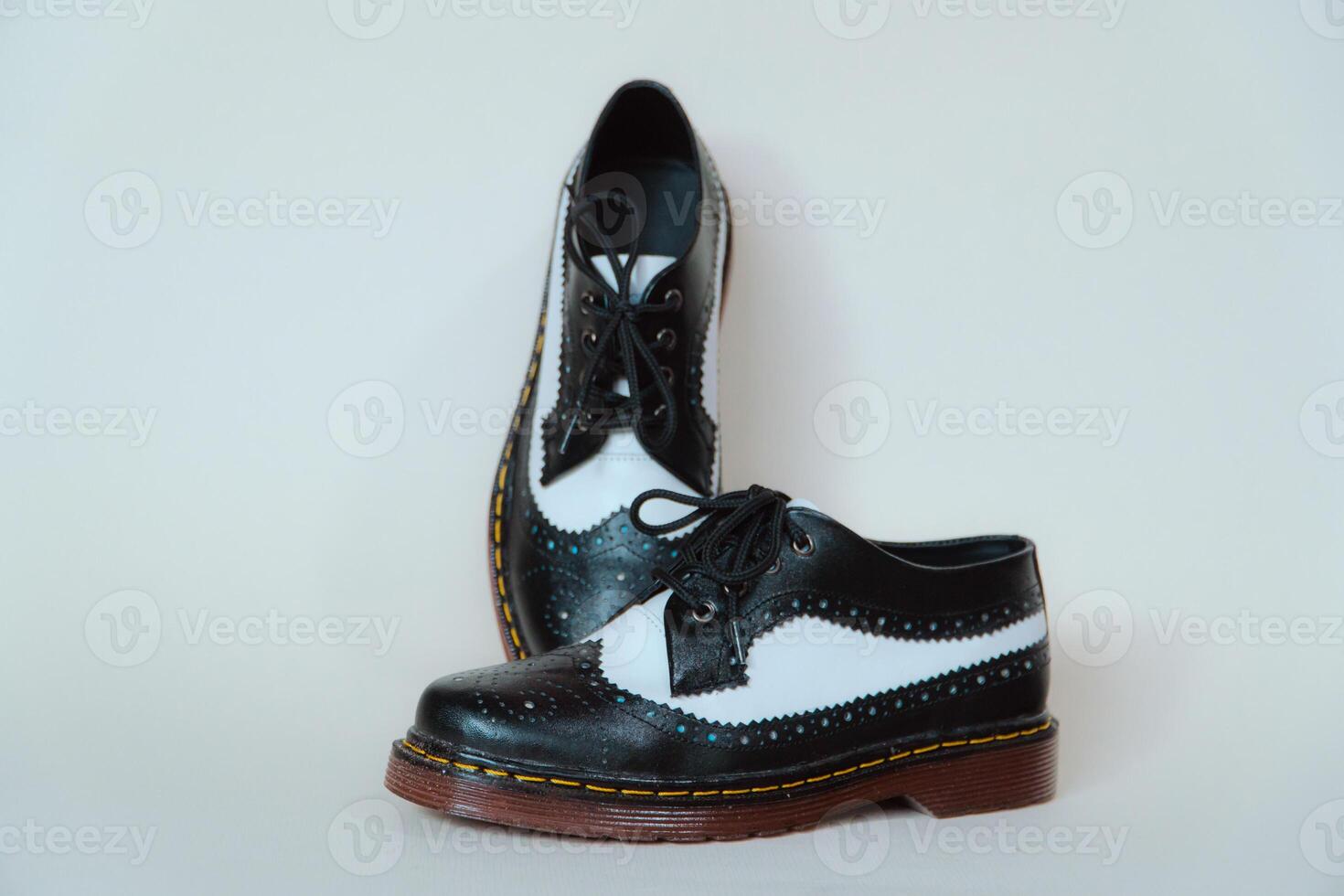 Close up of two-tone wingtip brogue shoes made from genuine cow leather. Studio shot of an elegant and shiny vintage shoe product on a white background photo