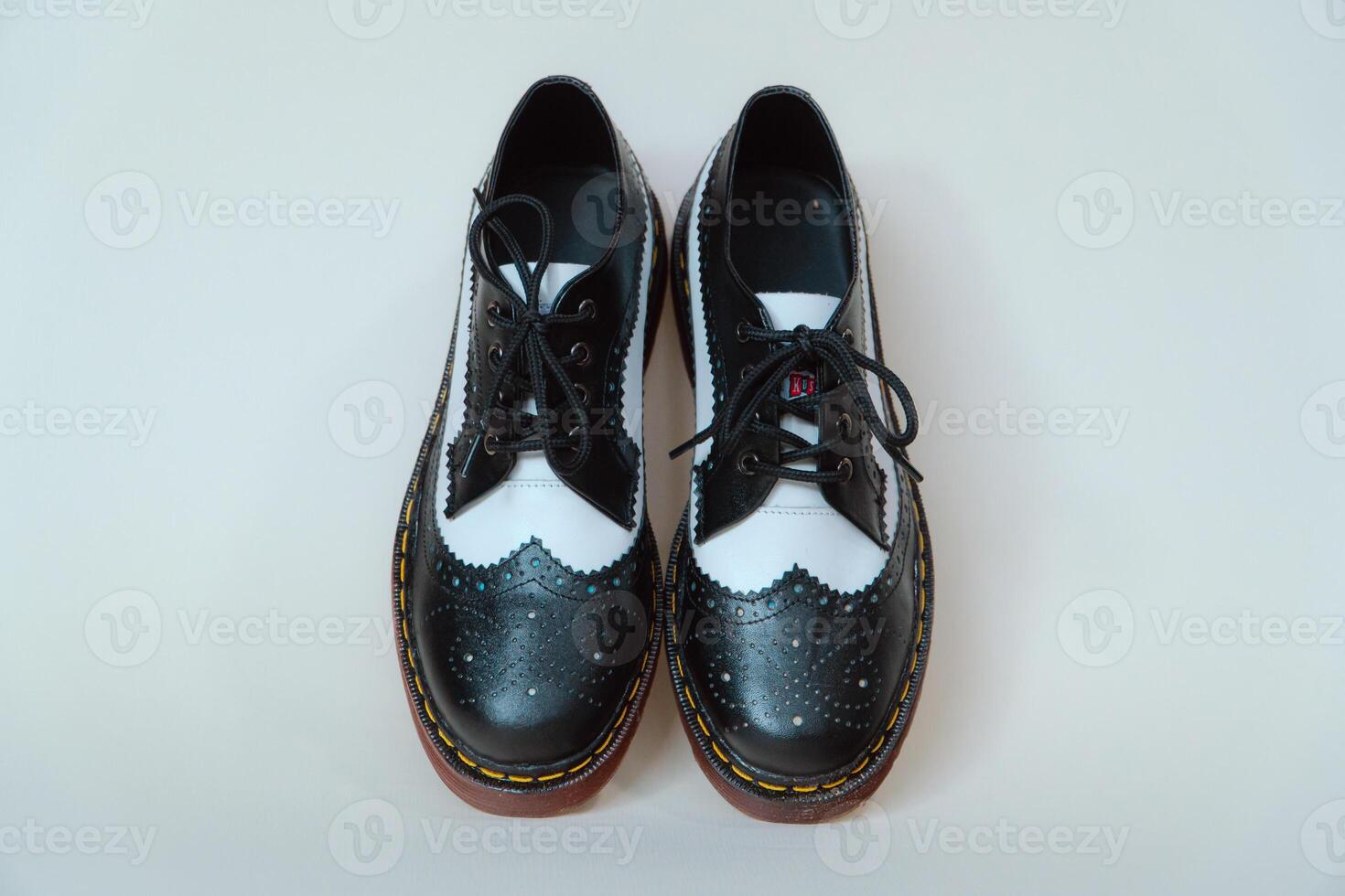 Close up of two-tone wingtip brogue shoes made from genuine cow leather. Studio shot of an elegant and shiny vintage shoe product on a white background photo