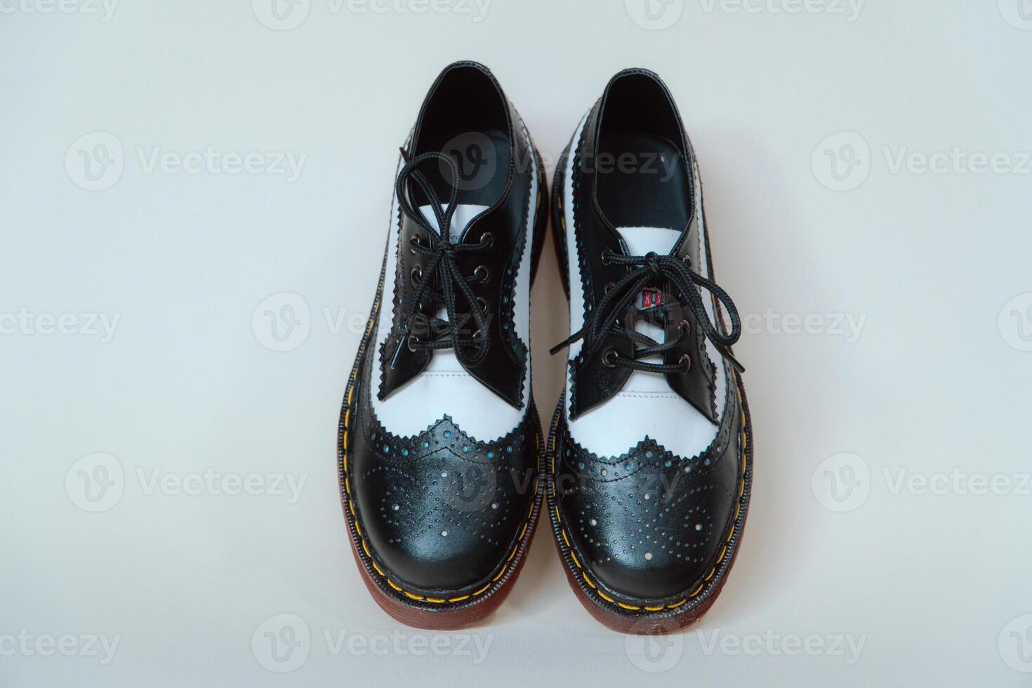 Close up of two-tone wingtip brogue shoes made from genuine cow leather. Studio shot of an elegant and shiny vintage shoe product on a white background photo