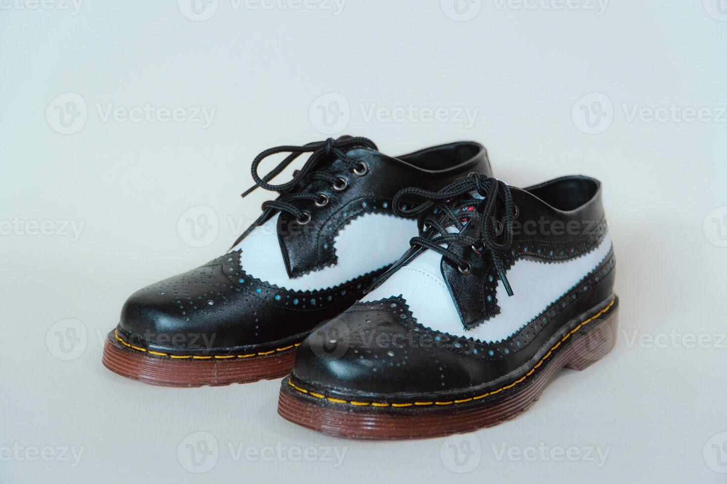 Close up of two-tone wingtip brogue shoes made from genuine cow leather. Studio shot of an elegant and shiny vintage shoe product on a white background photo