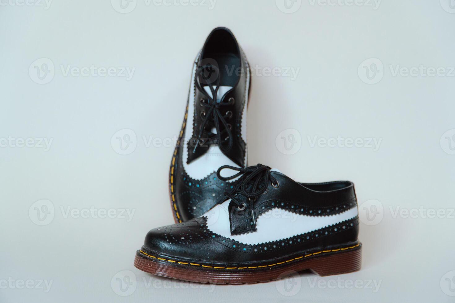 Close up of two-tone wingtip brogue shoes made from genuine cow leather. Studio shot of an elegant and shiny vintage shoe product on a white background photo