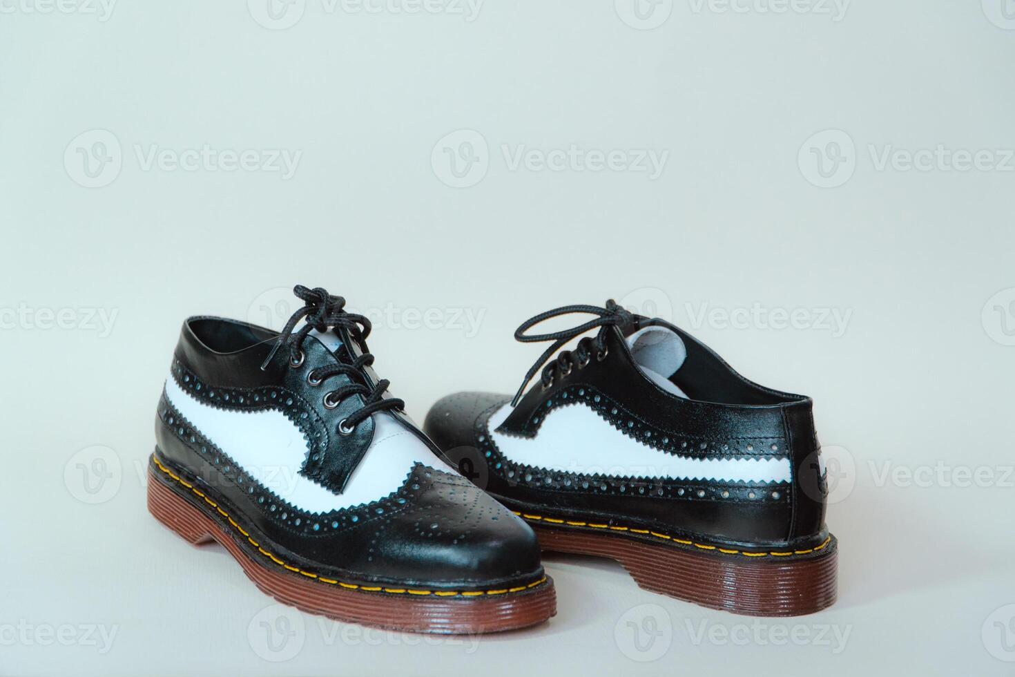 Close up of two-tone wingtip brogue shoes made from genuine cow leather. Studio shot of an elegant and shiny vintage shoe product on a white background photo