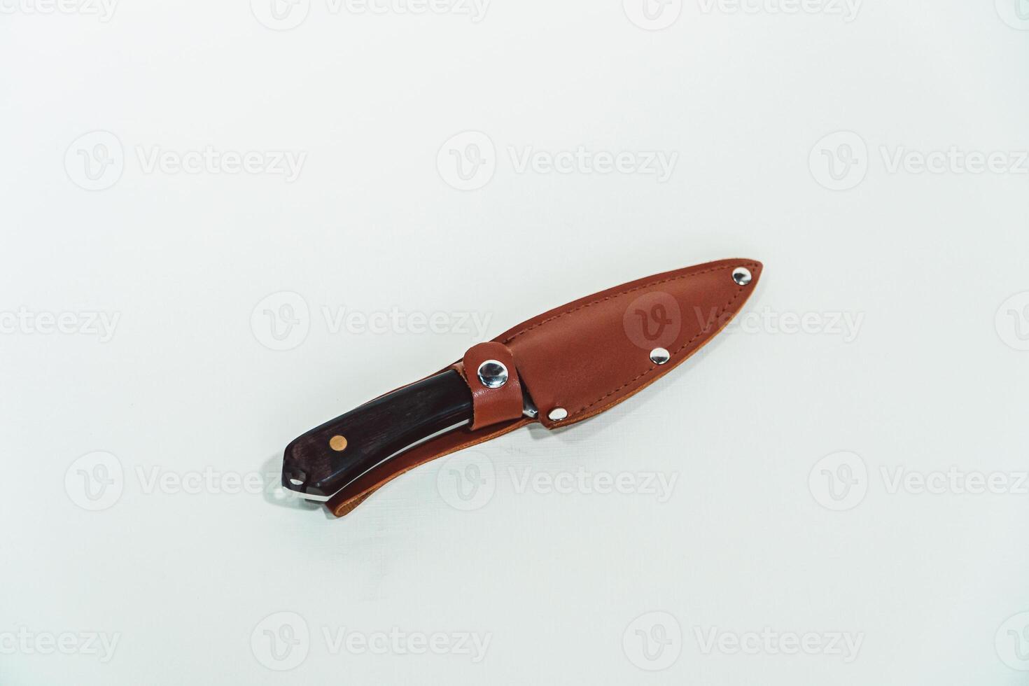 Close-up of a wooden handled adventure knife with a leather sheath. Pocket knife with a sharp stainless steel blade with a wooden handle, perfect for outdoor adventures and bushcraft activities photo