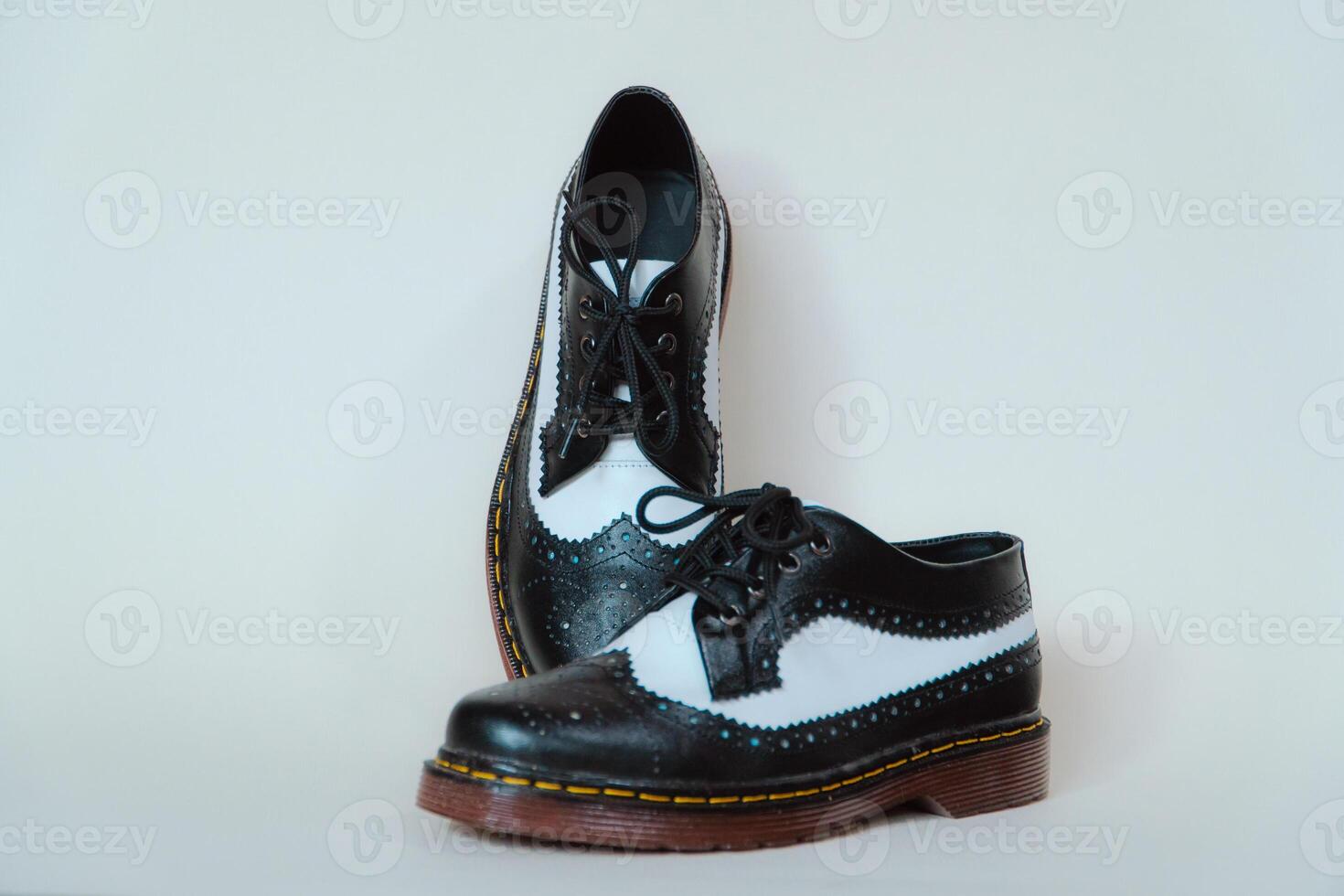 Close up of two-tone wingtip brogue shoes made from genuine cow leather. Studio shot of an elegant and shiny vintage shoe product on a white background photo