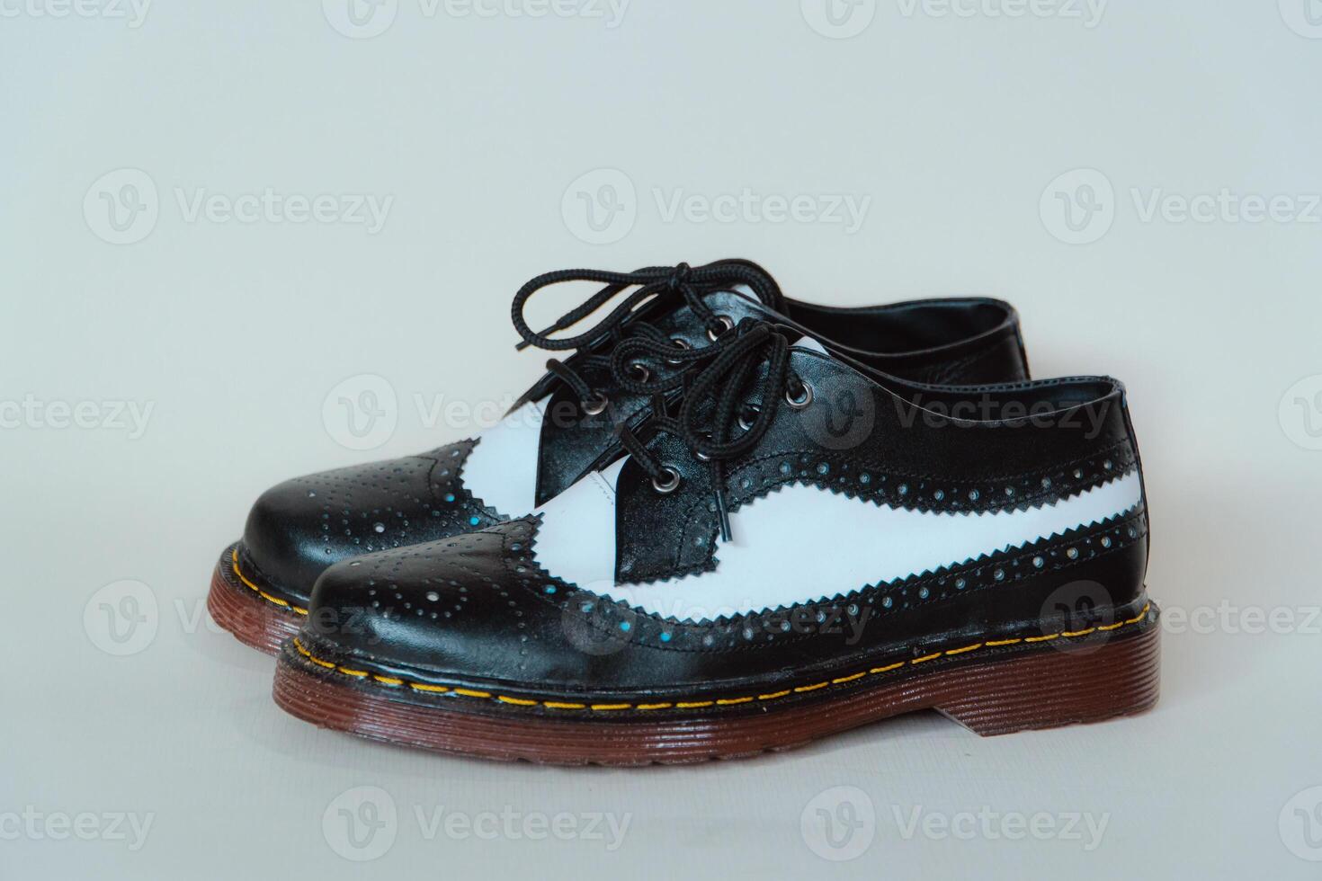 Close up of two-tone wingtip brogue shoes made from genuine cow leather. Studio shot of an elegant and shiny vintage shoe product on a white background photo