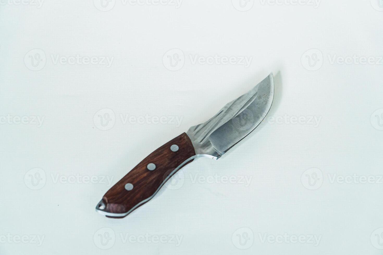 Close up of an adventure and bushcraft knife using a wooden handle. Knife with a sharp stainless steel blade with a wooden handle, perfect for outdoor adventures and bushcraft activities photo