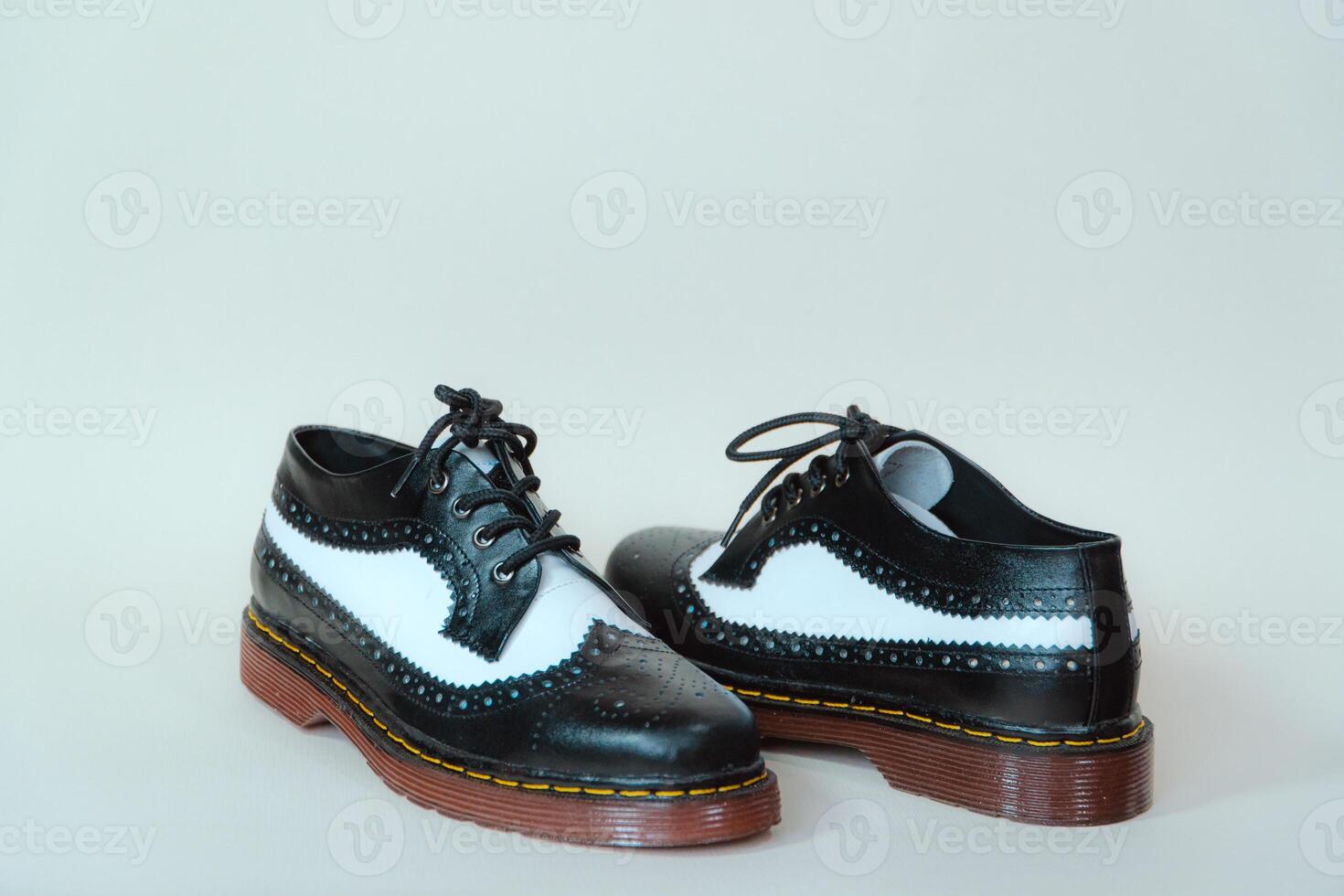 Close up of two-tone wingtip brogue shoes made from genuine cow leather. Studio shot of an elegant and shiny vintage shoe product on a white background photo