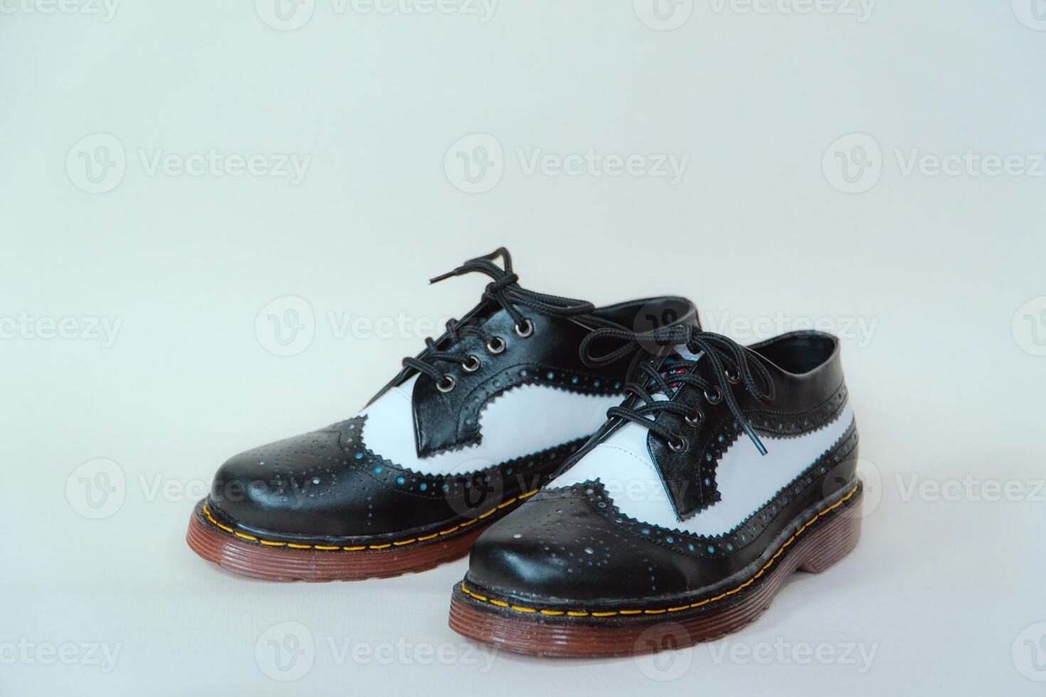 Close up of two-tone wingtip brogue shoes made from genuine cow leather. Studio shot of an elegant and shiny vintage shoe product on a white background photo