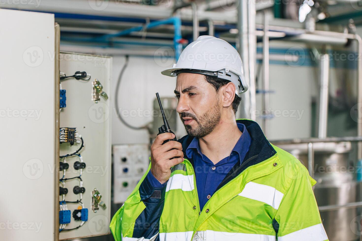 Engineer working, Factory male Latin worker in a oil and gas power plant with control operate order with walkie-talkie communication at work photo