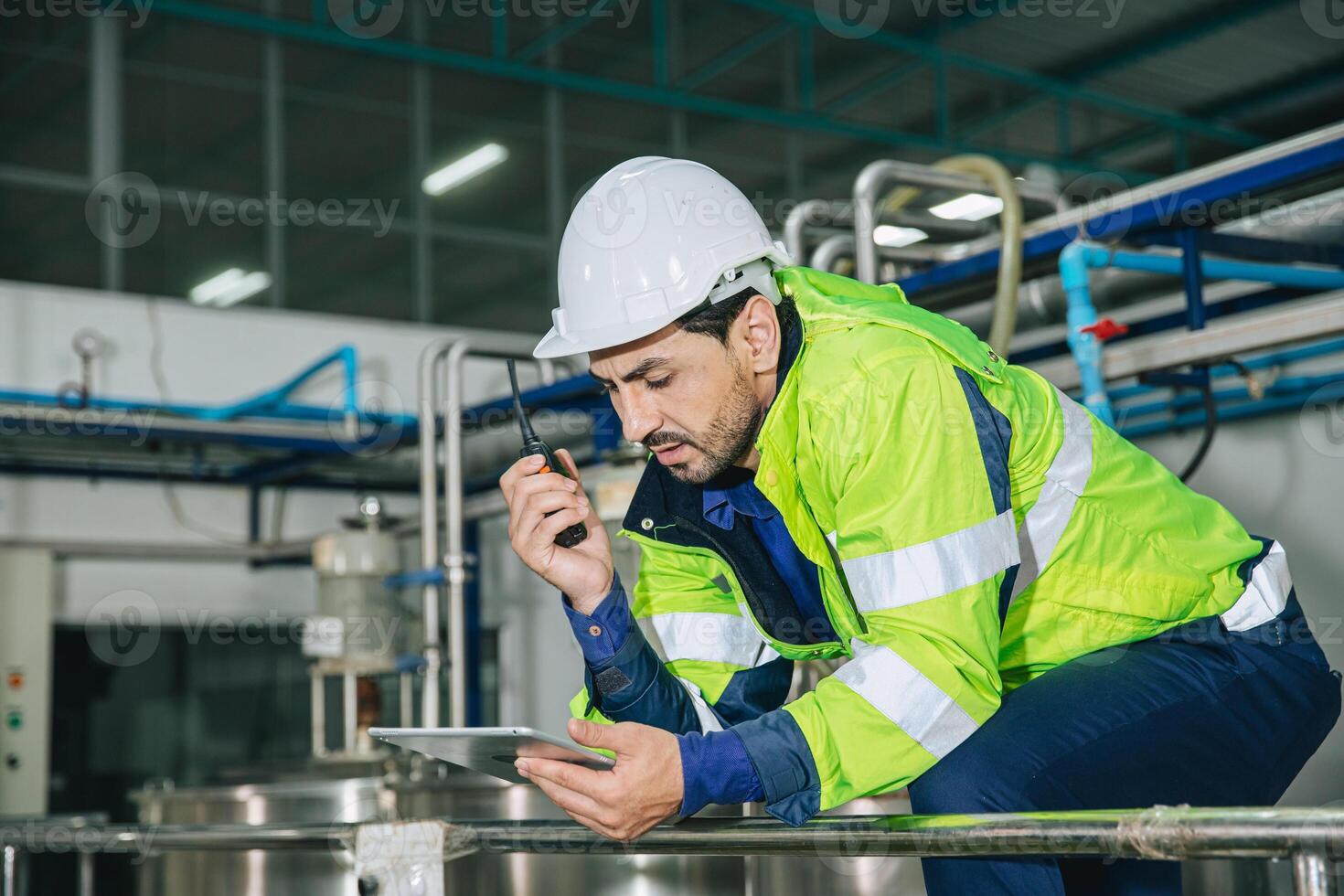 Engineer working, Factory male Latin worker in a oil and gas power plant with control operate order with walkie-talkie communication at work photo