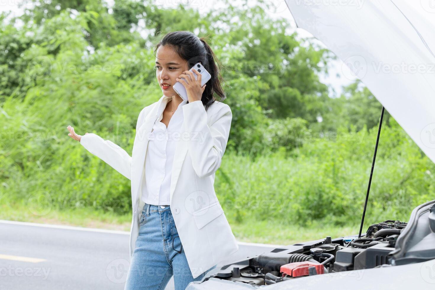 Young woman calling help and insurance auto service with a problem broken car on the road, angry upset worry expression. photo