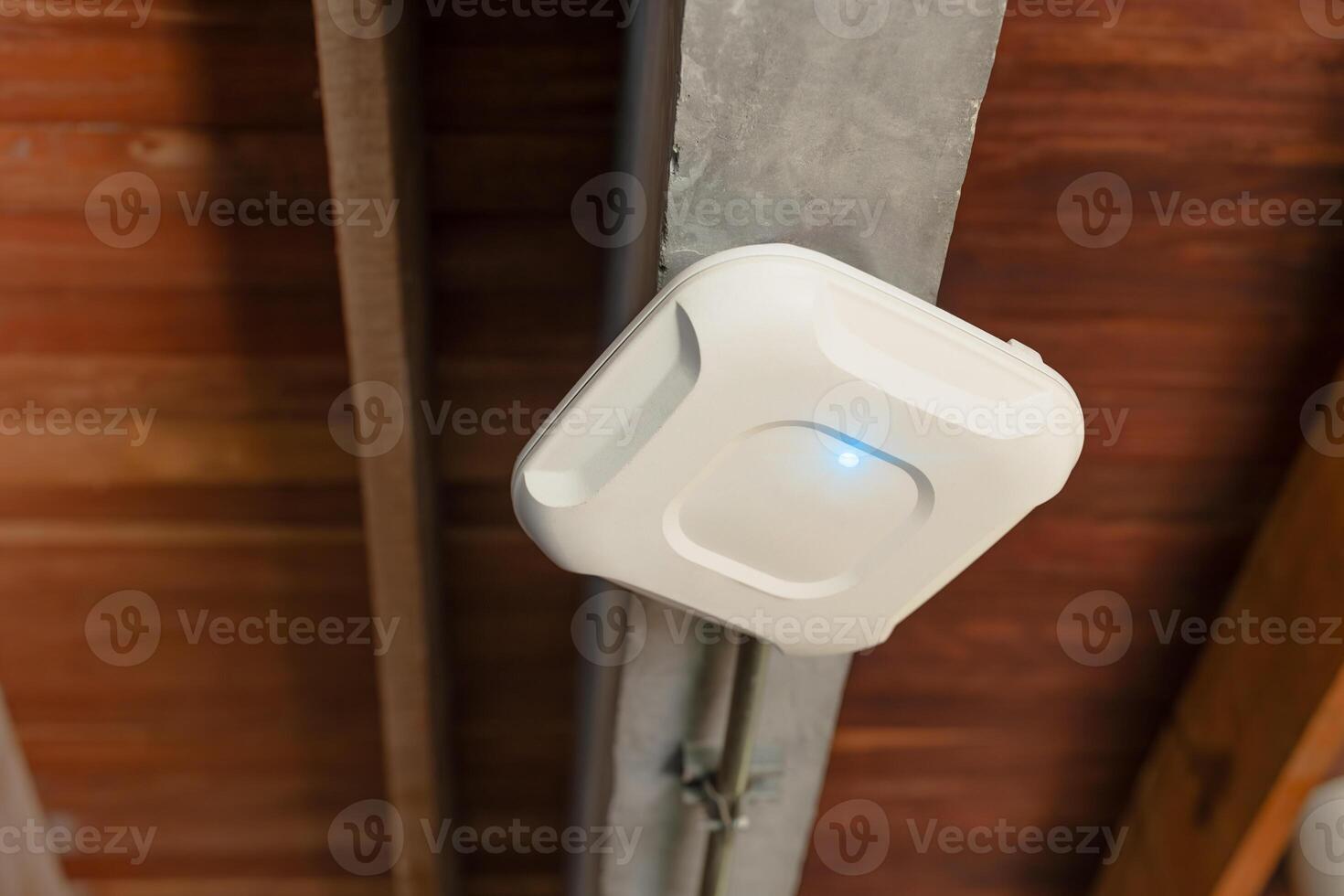 Wireless router for internet local network at ceiling. Indoor networking technology. WIFI router or Wireless Access Point setup at ceiling for Internet connection office space or cafe. photo