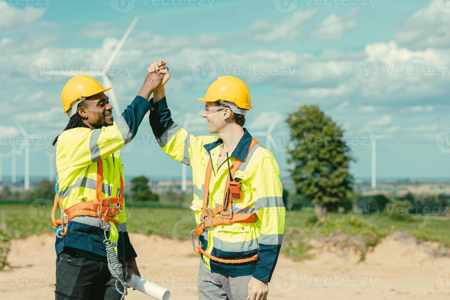 Engineer team stress hand together happy smiling greeting job done at Turbines field wind electricity power generator farm outdoor. photo