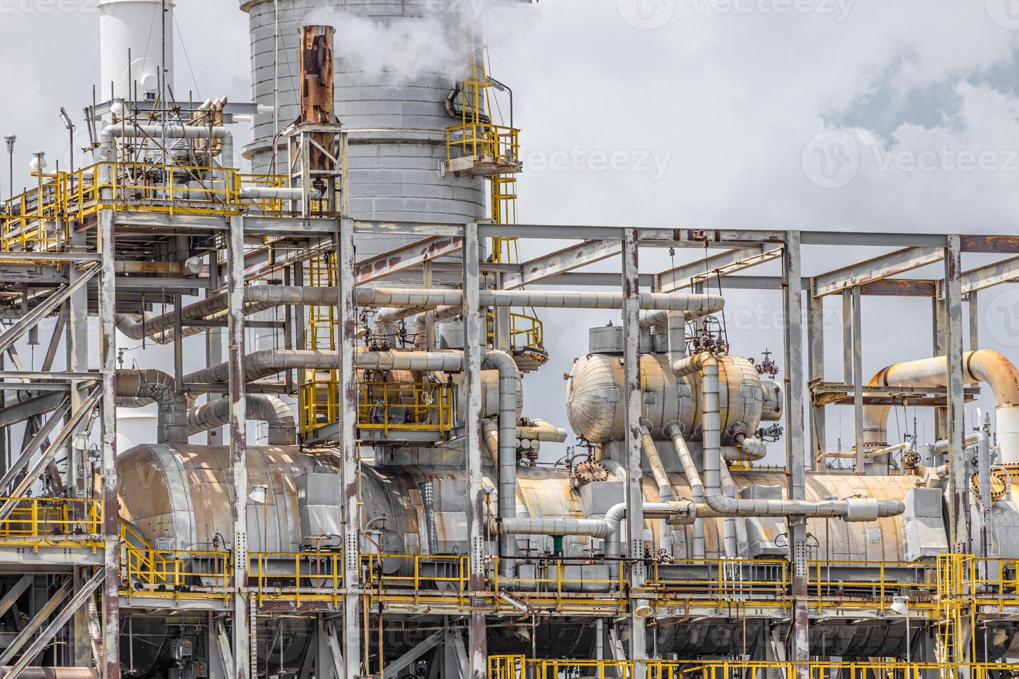 Oil petroleum refinery plant building distillation columns tower, Closeup part of fuel gas pipe complex, Crude oil petrochemical industrial building. photo