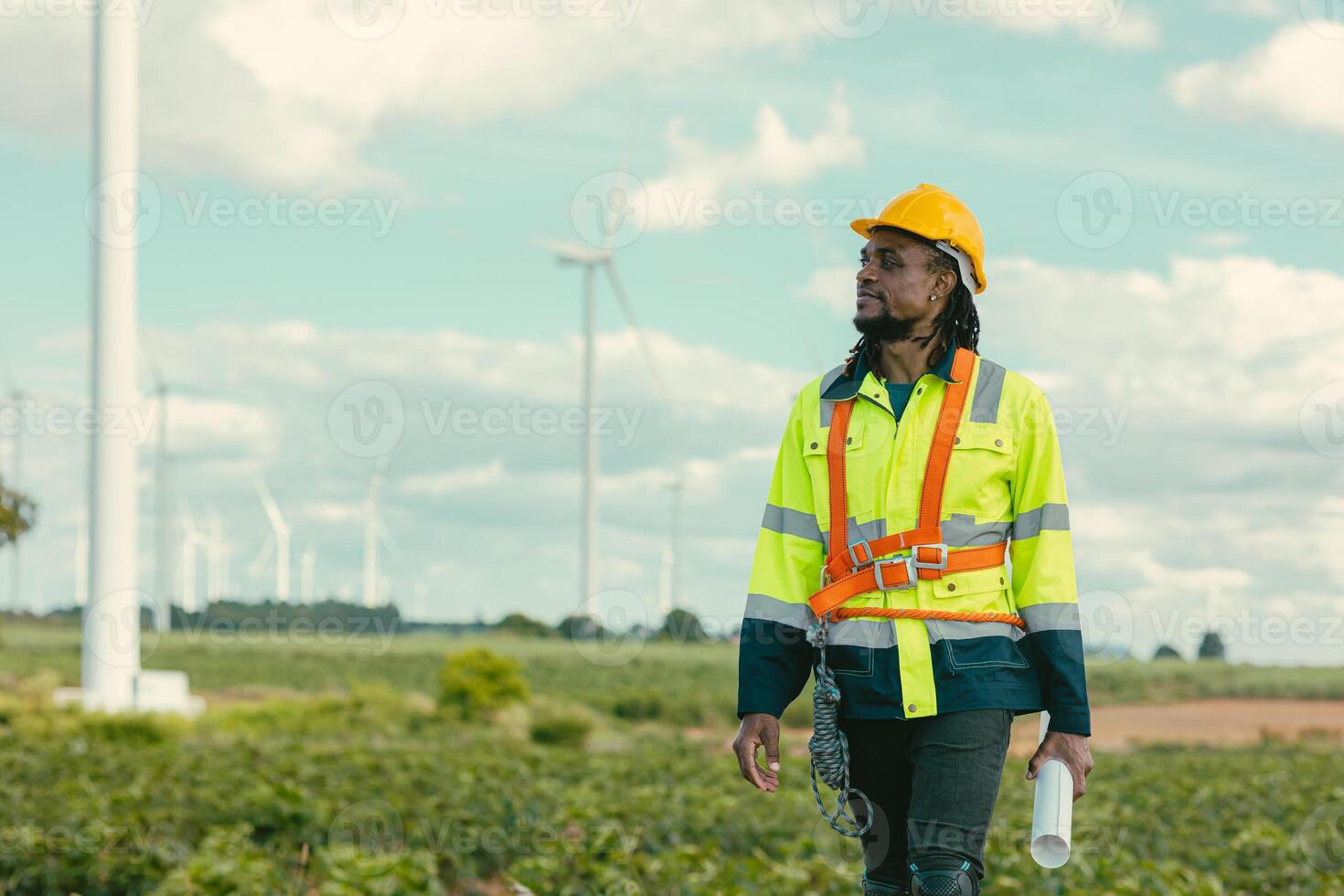 African black engineer technician male worker working service maintenance wind turbine at Wind Turbines electricity generator farm field outdoors. photo