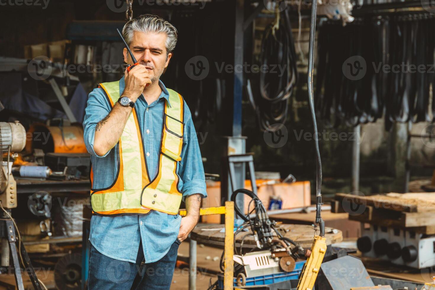 Italian worker engineer construction site control radio operation. Foreman working crane working order by walkie talkie. photo