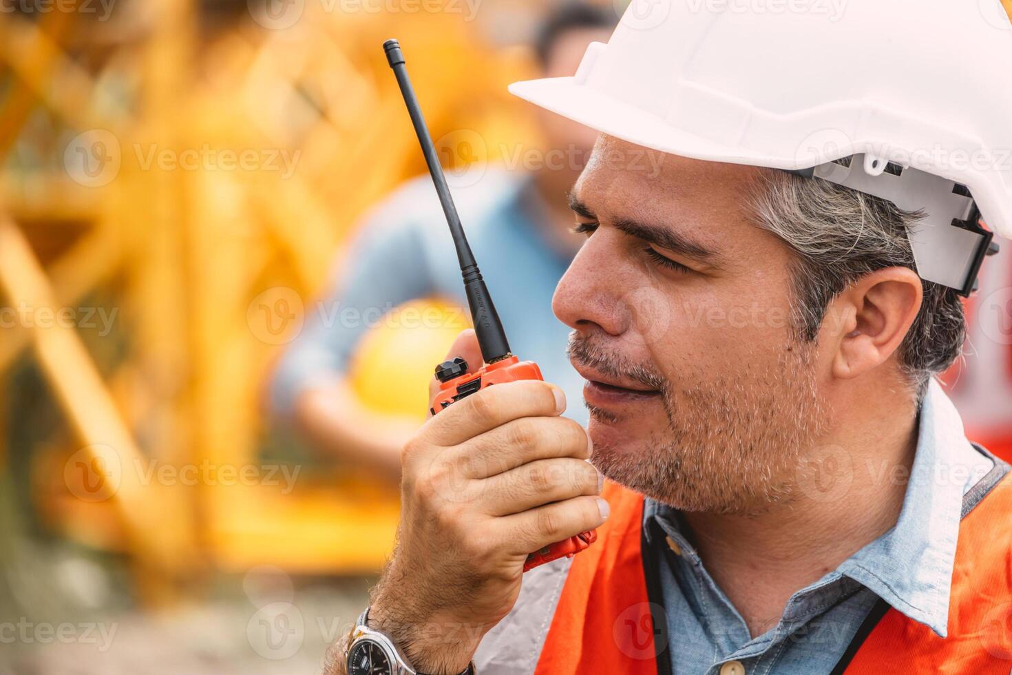 Senior construction engineer worker control operate construction site with radio communication. Foreman order crane tower working by walkie talkie radio. photo
