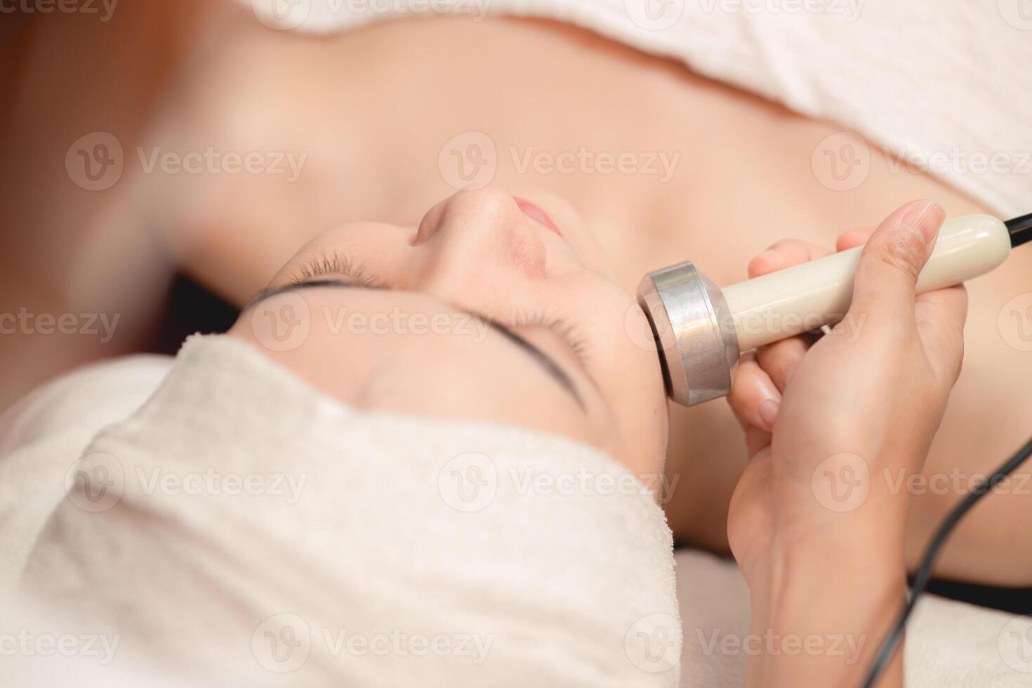 Beautiful women face skin treatment, Ultrasonic massage device for Facial Lifting Activate Collagen and Skin Tightening in beauty salon spa. photo