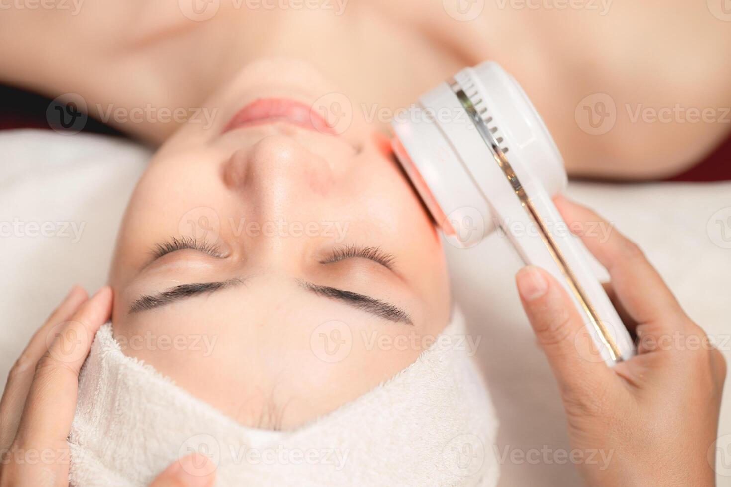 closeup people using Ultrasonic massage device for Facial Lifting Activate Collagen and Skin Tightening in beauty salon spa. photo