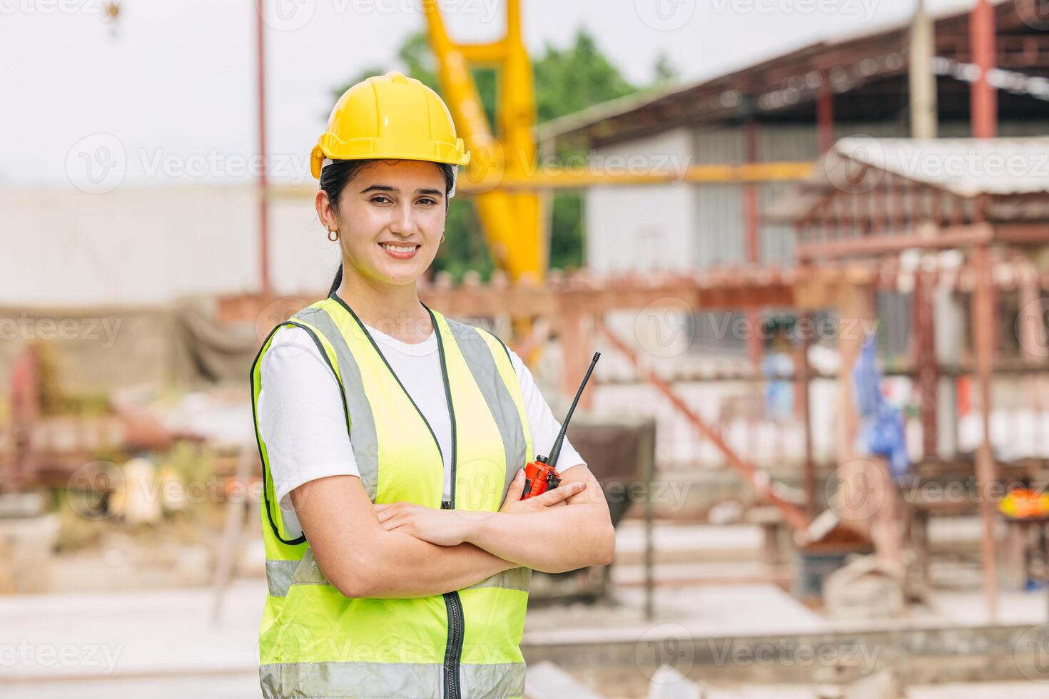 Professional engineer female working in construction site standing arm crossed happy smiling. photo