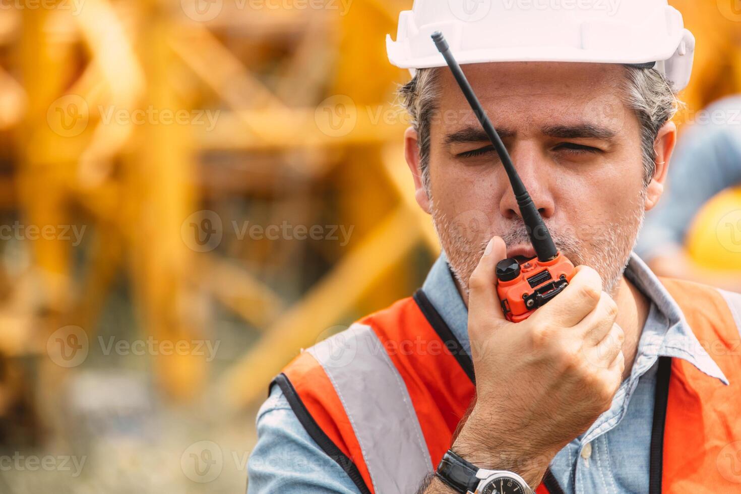 Italian worker engineer construction site control radio operation. Foreman operate crane tower working order by walkie talkie. photo