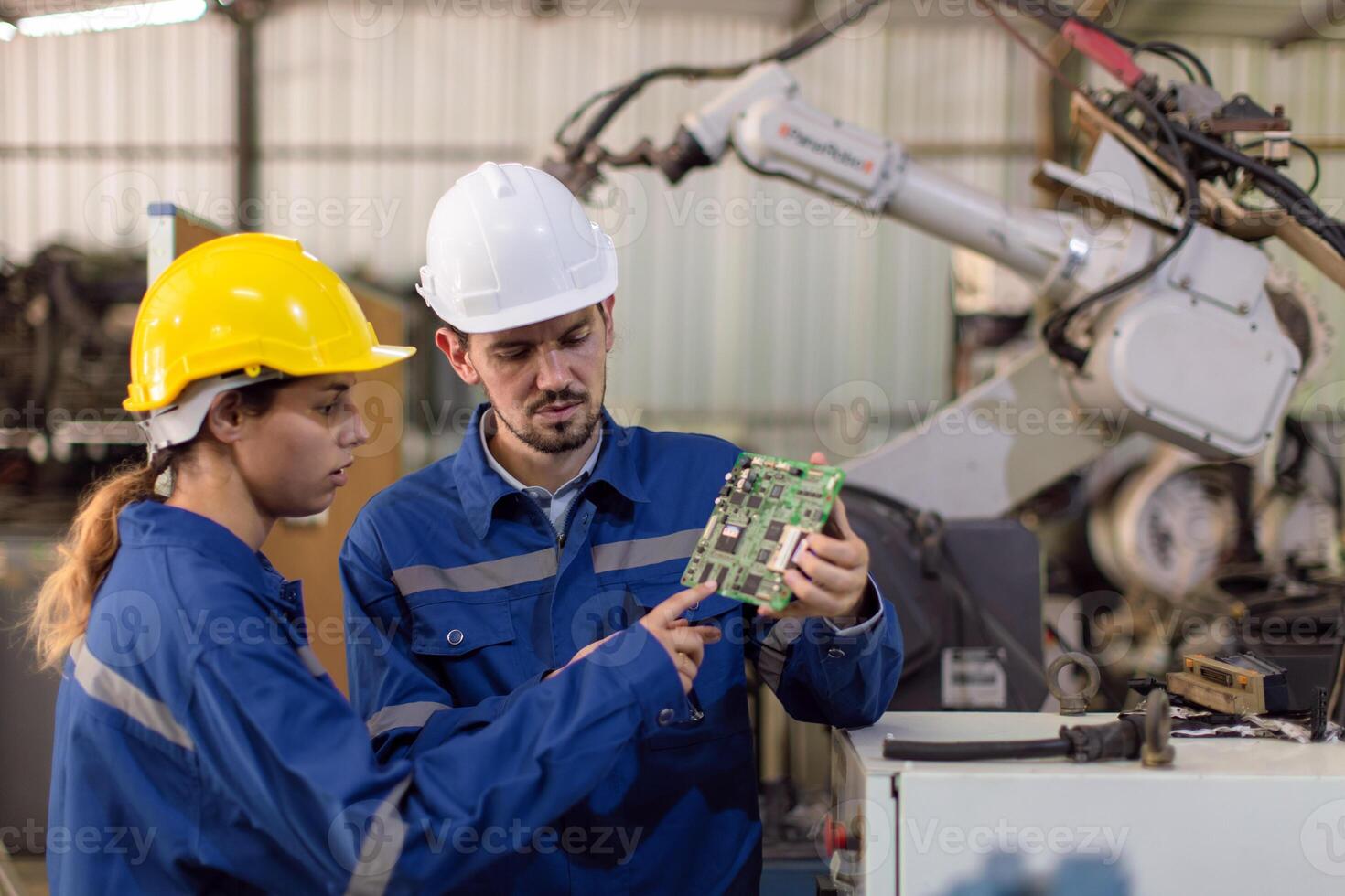 Happy engineer worker team service replace broken part of automatic industry robotic welding arm. Mechanic team repair maintenance robot machine in workshop. photo